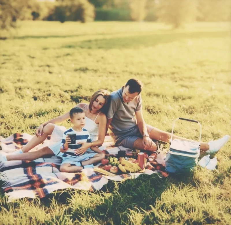 A family picnic on a summer lawn on Atelier film, with the caption written on the border